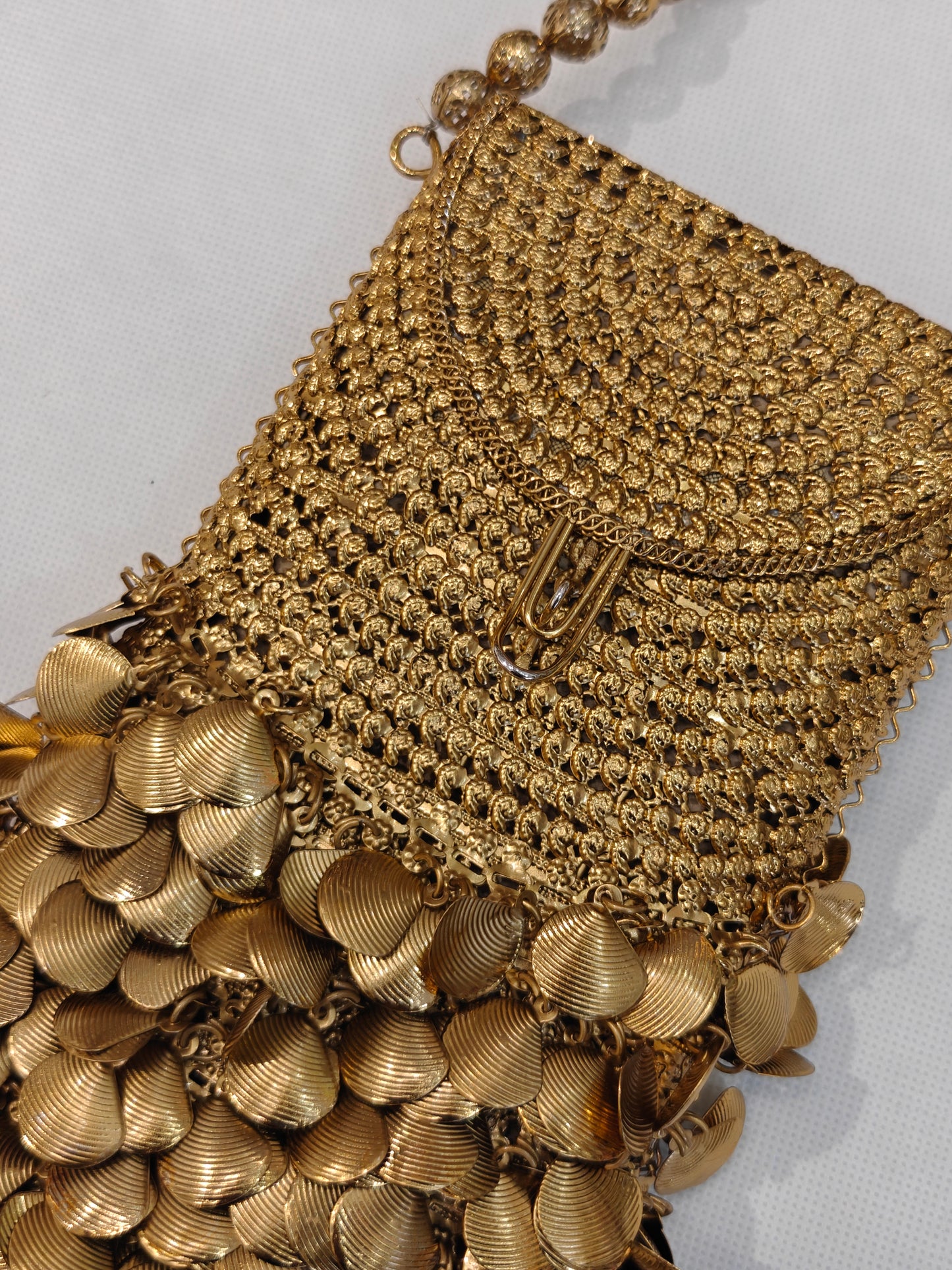 Handcrafted gold brass mesh mobile purse with cascading metal coin fringe, textured weave body and filigree gold bead loop handle — bridal wedding clutch bag by The Wedding Station Meerut