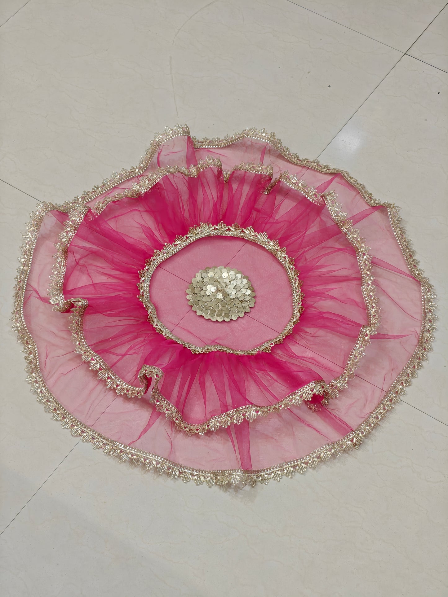 Pink net thaal cover with golden lace border and decorative centre embellishment for wedding and pooja thalis, 25 inches diameter.
