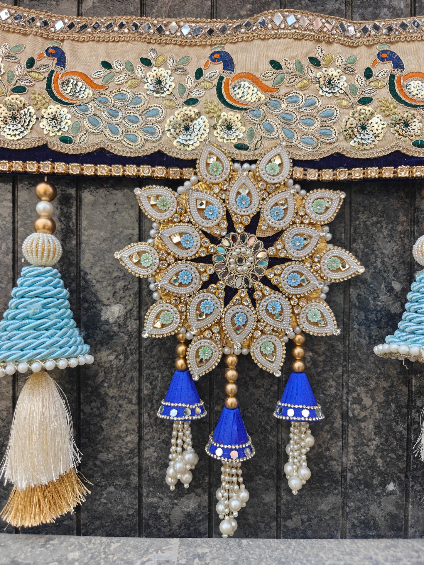 Cream blue peacock embroidery bandhanwar close-up with mirror star pendant blue silk jhumki and pearl tassels