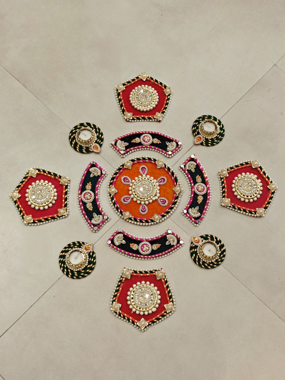Orange and Green kundan rangoli set with pearl-bordered tealight holders arranged in a floor pattern