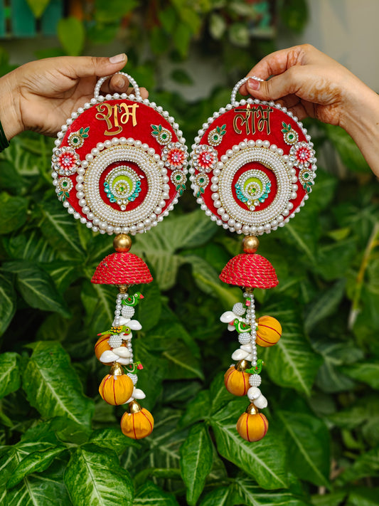 Red Shubh Laabh Diwali hanging with pearl detailing, gold lettering and colourful decorative pumpkin charms