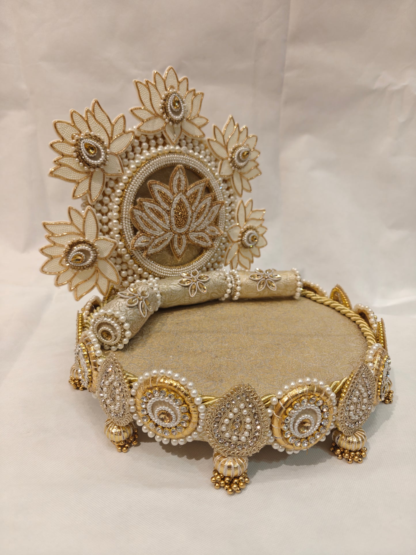 Angled view of handcrafted ivory lotus garden Singhaasan for Ladoo Gopal — 12 inch MDF deity throne with lotus flower backdrop, brocade seating and gem teardrop border by The Wedding Station