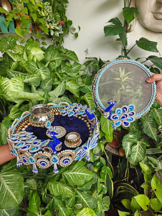 Royal blue peacock themed Karva Chauth thali set with decorated steel thali, steel kalash, candle, pearl embellishments and matching decorated channi