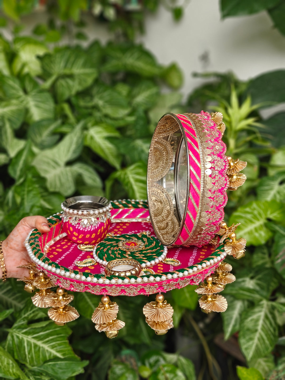 Pink and green designer Karva Chauth thali set with decorated steel thali, ornate kalash, steel channi, candle, pearl detailing and golden ghungroo hanging latkans