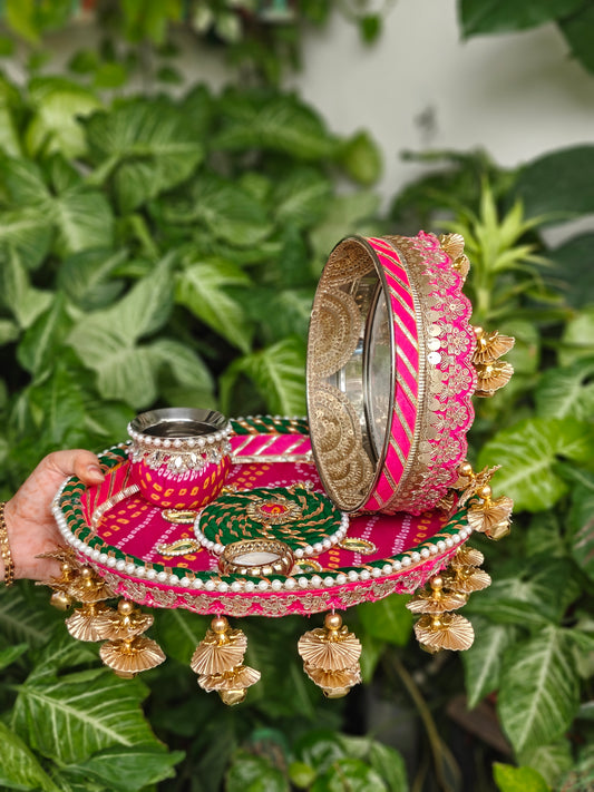 Pink and green designer Karva Chauth thali set with decorated steel thali, ornate kalash, steel channi, candle, pearl detailing and golden ghungroo hanging latkans