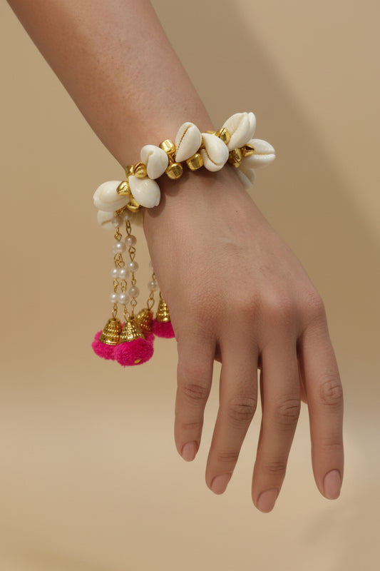 shell bracelet with gold accents, pearl chain danglers, and Rani pom poms — Haldi and Mehendi jewellery by The Wedding Station