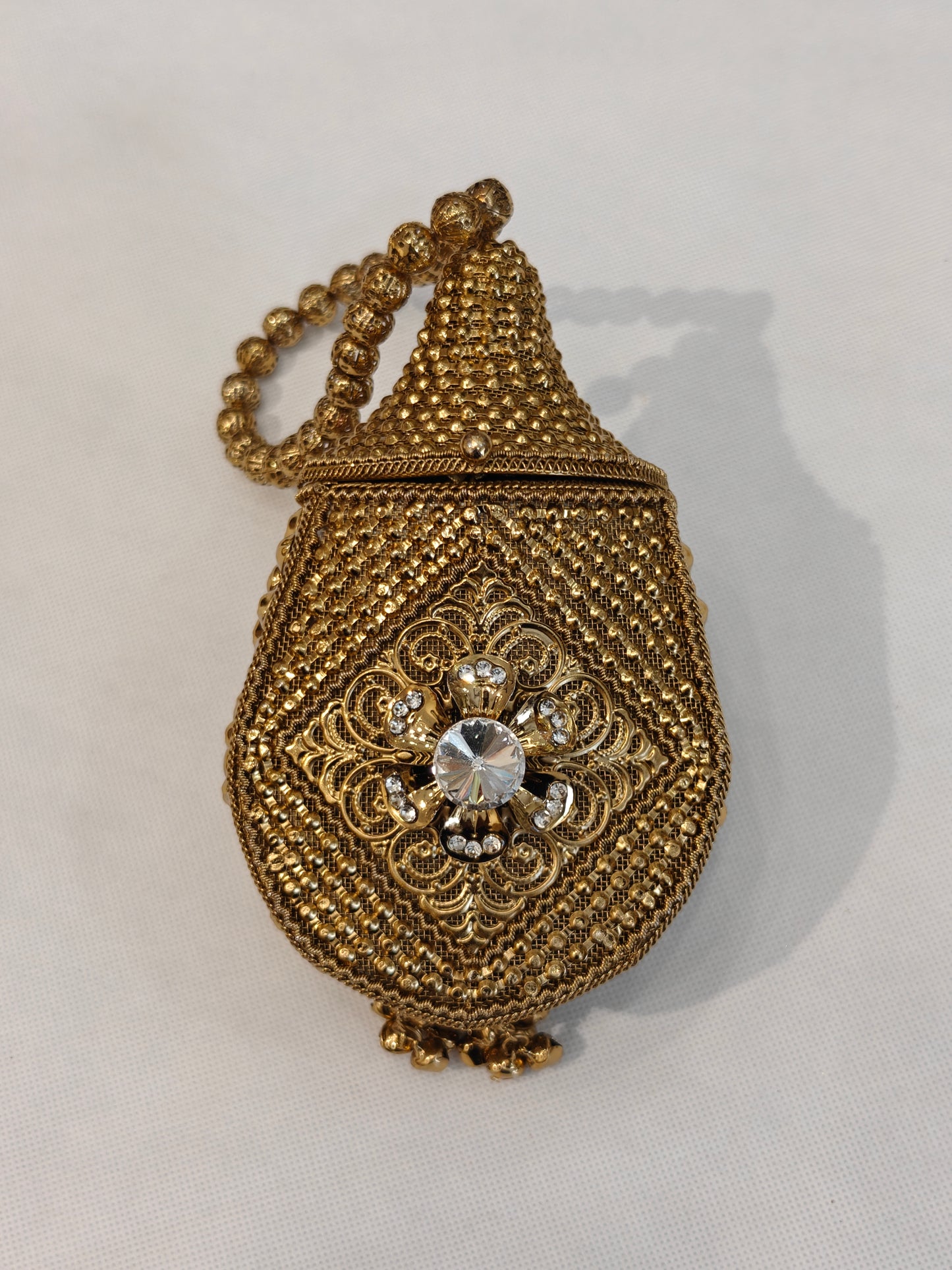 Handcrafted gold brass mesh teardrop potli bag with filigree scrollwork medallion, solitaire crystal rhinestone, scalloped base and filigree bead loop handle — bridal wedding potli by The Wedding Station Meerut