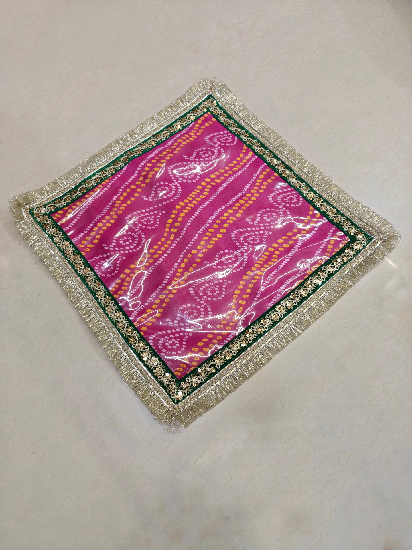 Pink Bandhani Dupion silk mangodi mat with transparent PVC sheet, gold sequin border and silver zari fringe, 20x20 inches, for Indian wedding rituals