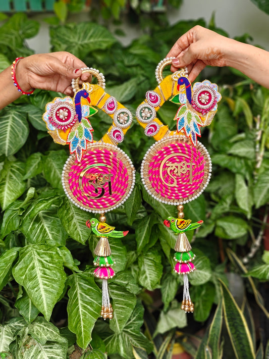 Handcrafted pink and yellow Peacock Shubh Laabh hanging with traditional Indian festive embellishments, 20 inches x 7 inches