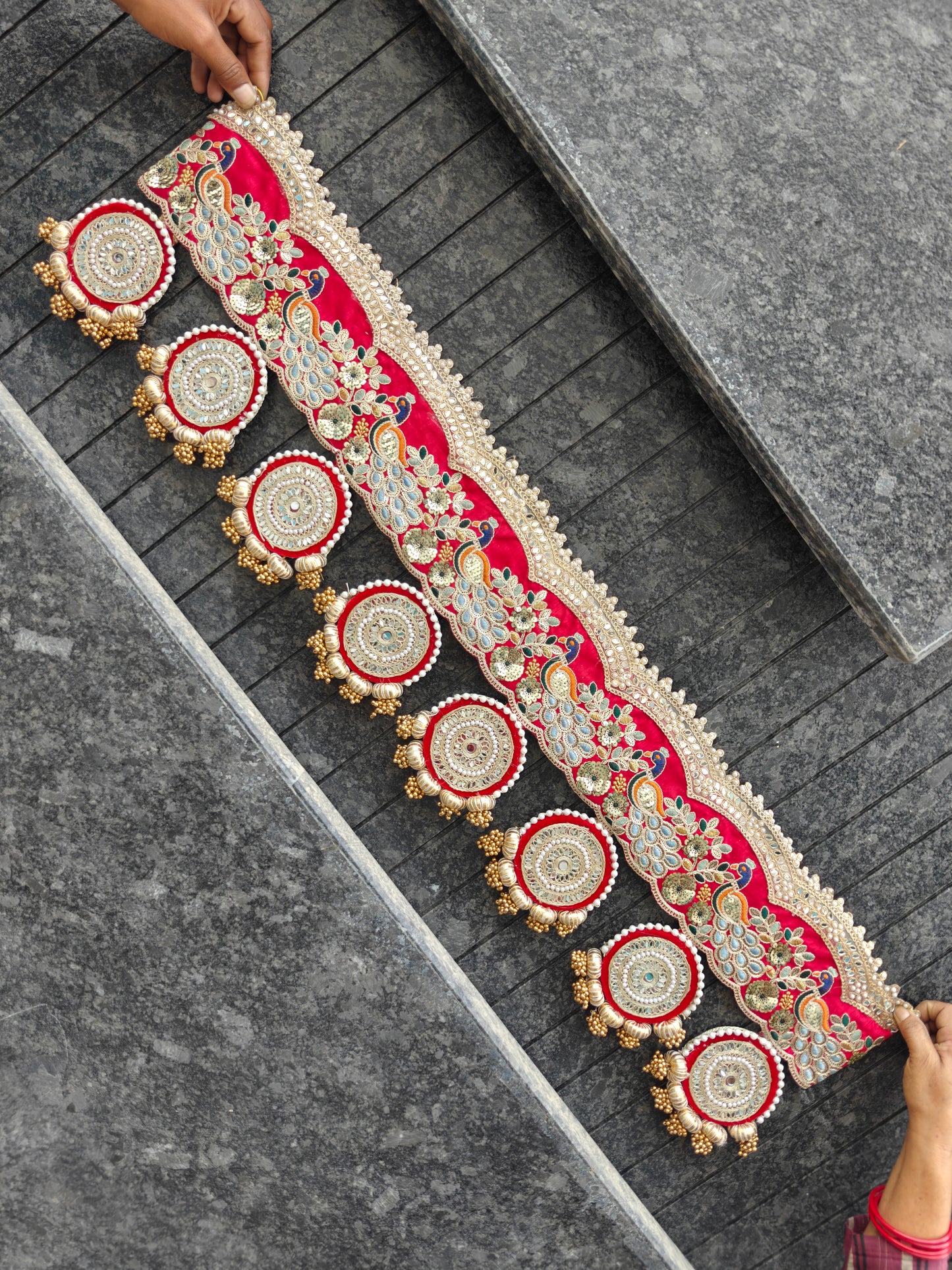 Close-up of peacock and floral embroidery on red Bandhanwar