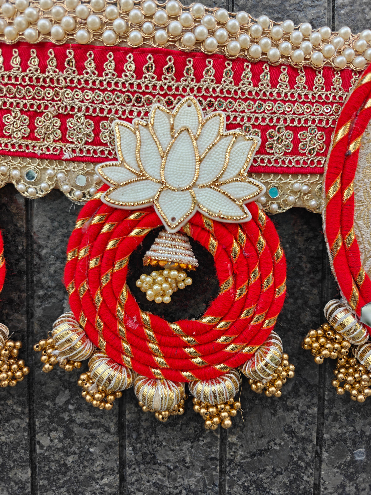 Close-up of hand beaded rainbow crown on Krishna toran