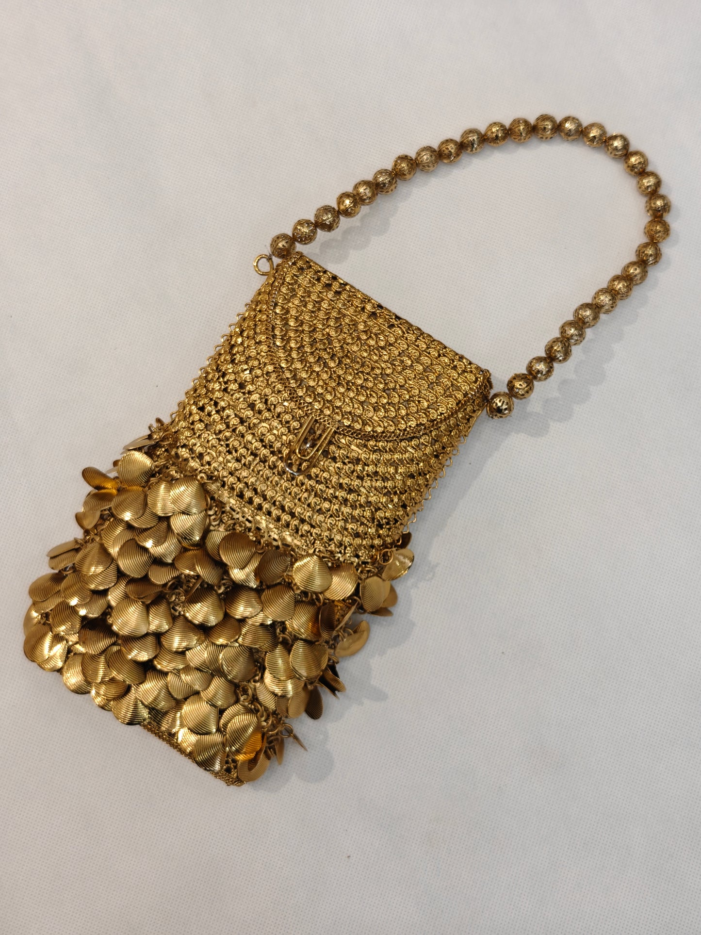 Handcrafted gold brass mesh mobile purse with cascading metal coin fringe, textured weave body and filigree gold bead loop handle — bridal wedding clutch bag by The Wedding Station Meerut