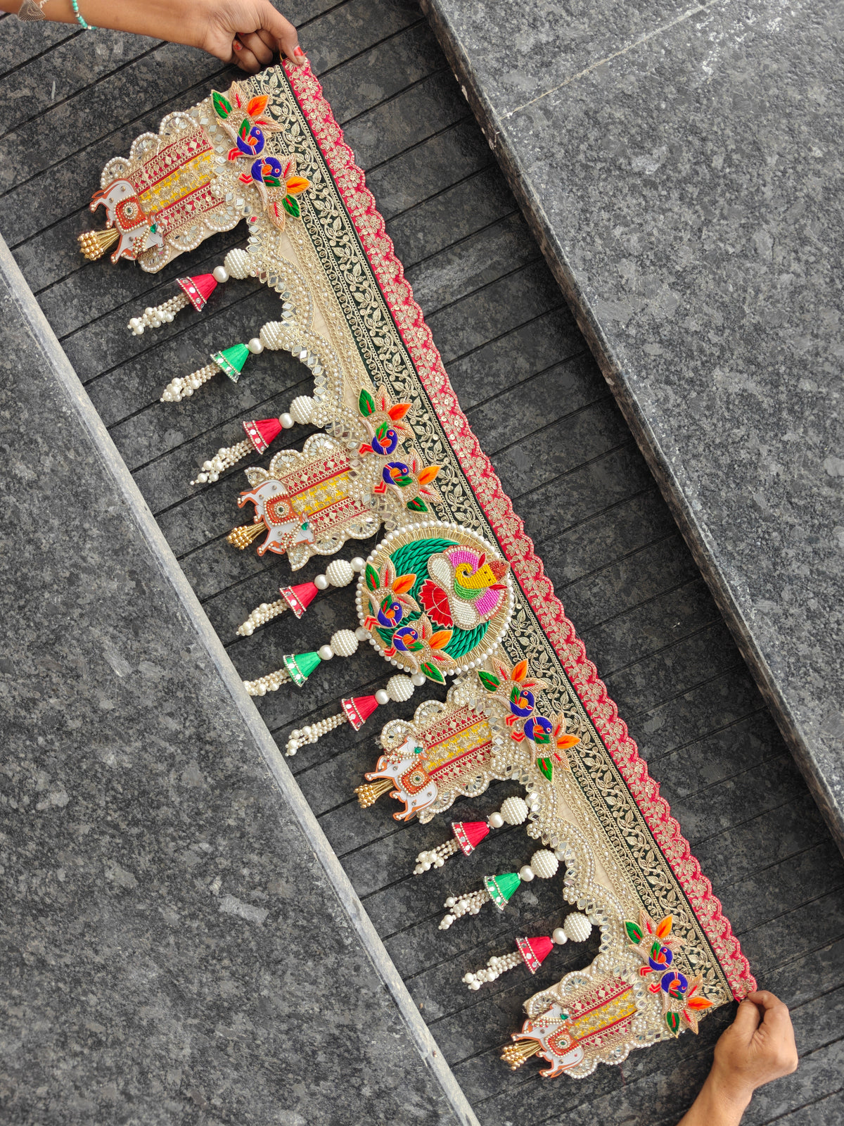 Embroidered red green and gold toran with peacock motifs, mirror work, zari lace and pearl latkans