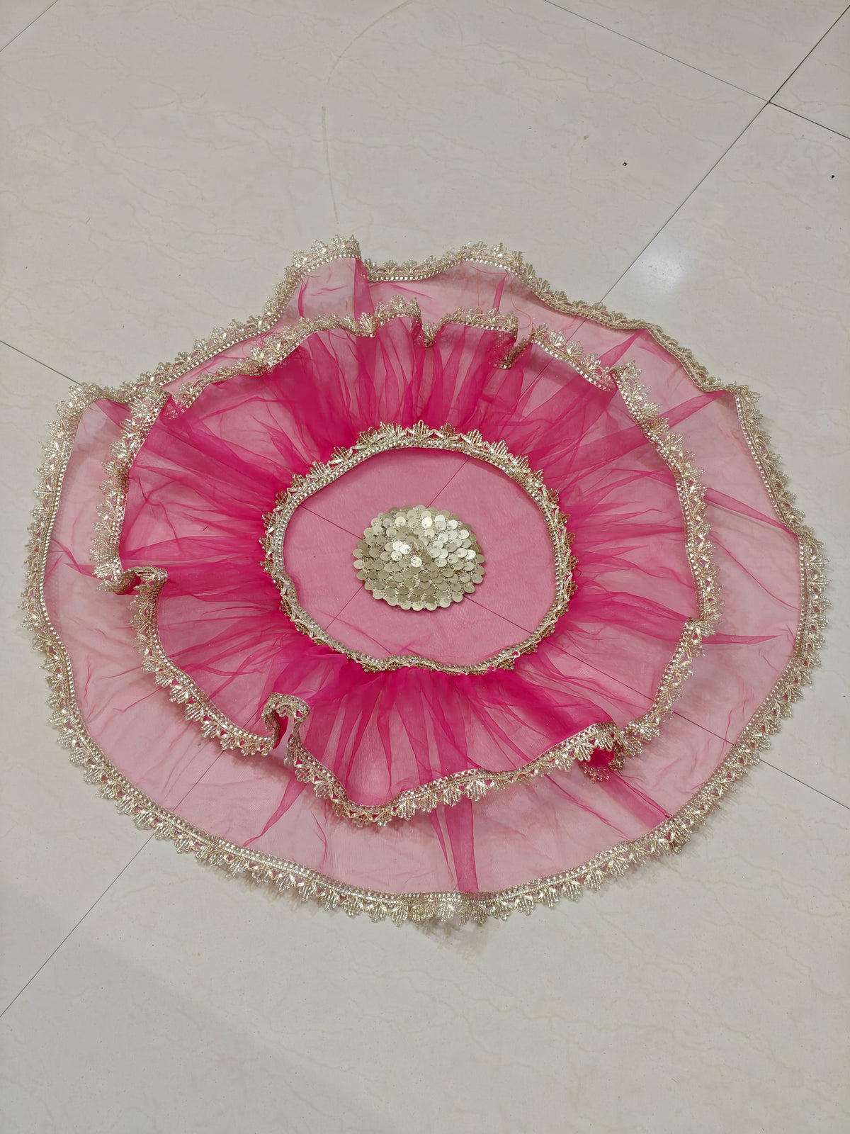 Pink net thaal cover with golden lace border and decorative centre embellishment for wedding and pooja thalis, 25 inches diameter.