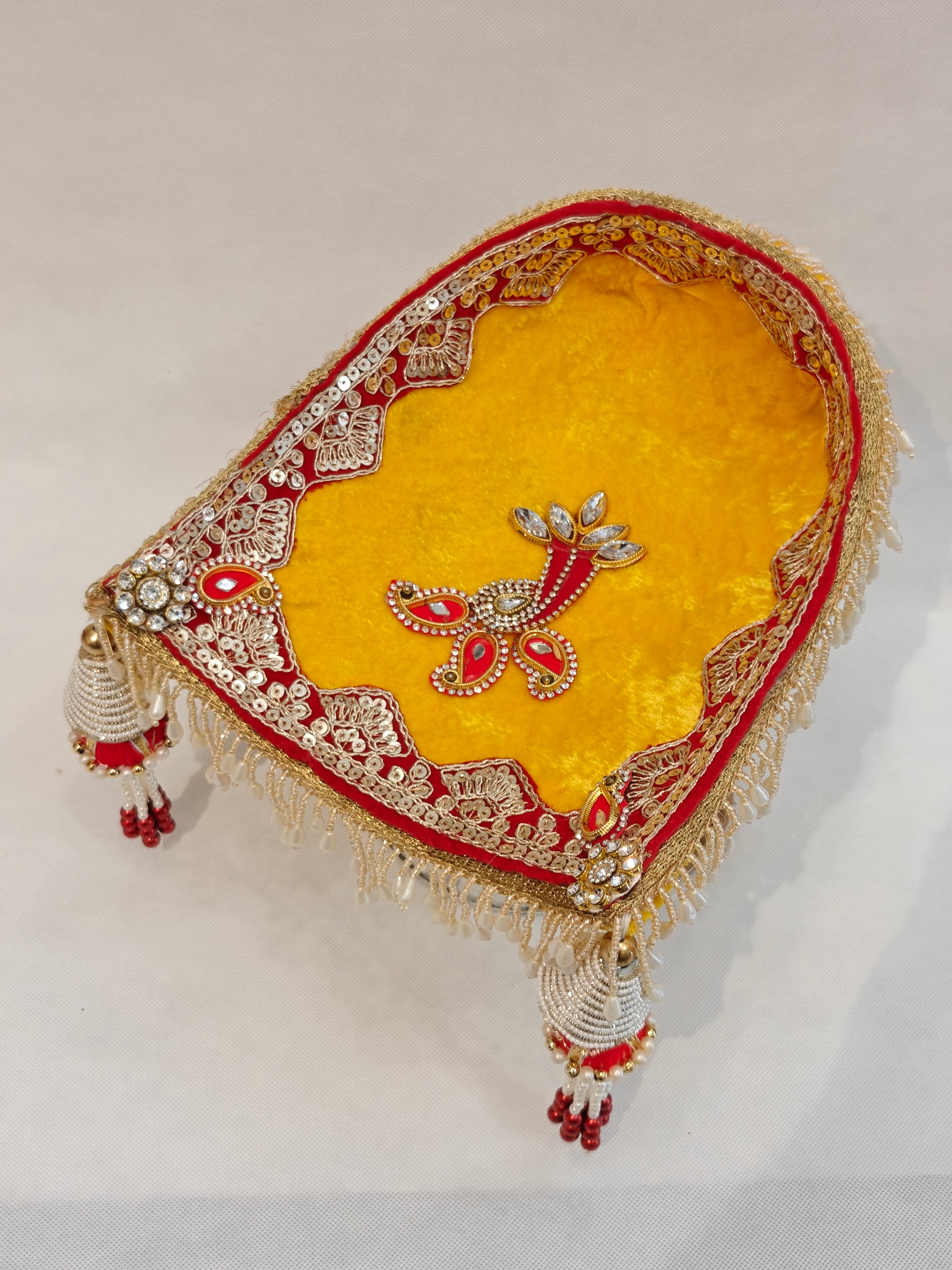 Yellow velvet soupda with red zari border, crystal peacock appliqué and white bead tassel drops — small Indian wedding ritual tray 8x7 inch by The Wedding Station