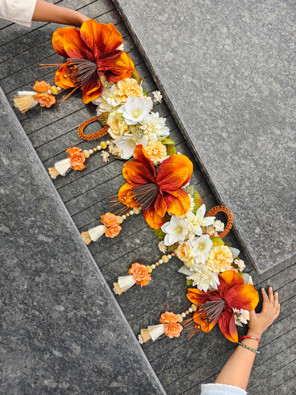 Rust and cream floral toran with rust lilies, white magnolias, dahlias and pearl latkans with gold tassels