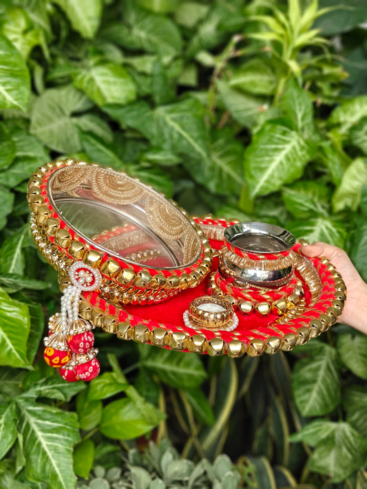 Red and gold Rajsi Ghunghroo Karva Chauth thali set with decorated steel channi, kalash, steel glass, candle and golden ghunghroo border.