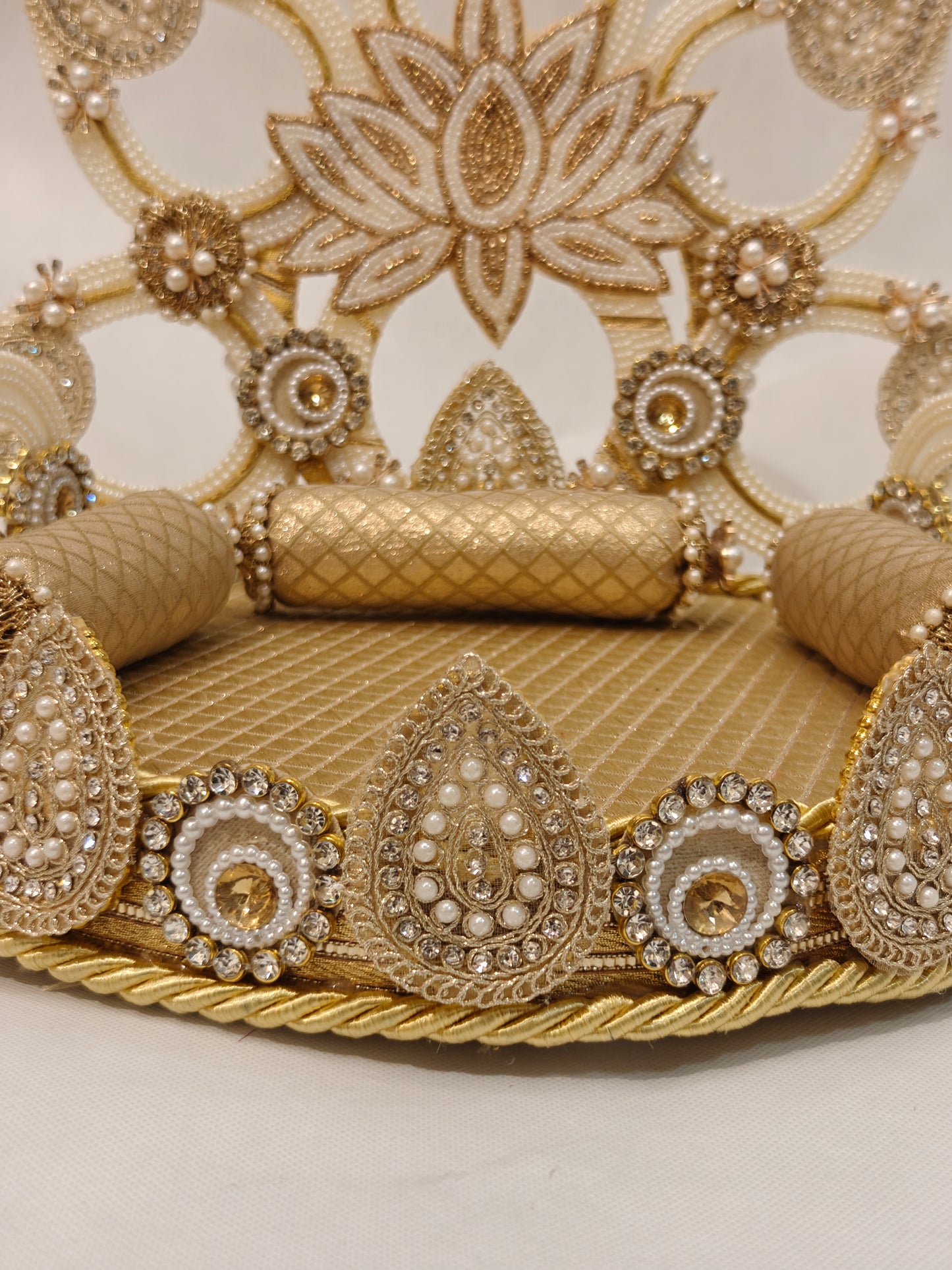 Detail view of gold lotus Singhaasan base border — teardrop and circle motifs with seed pearls, champagne rhinestones, gold rope trim and quilted fabric seating by The Wedding Station