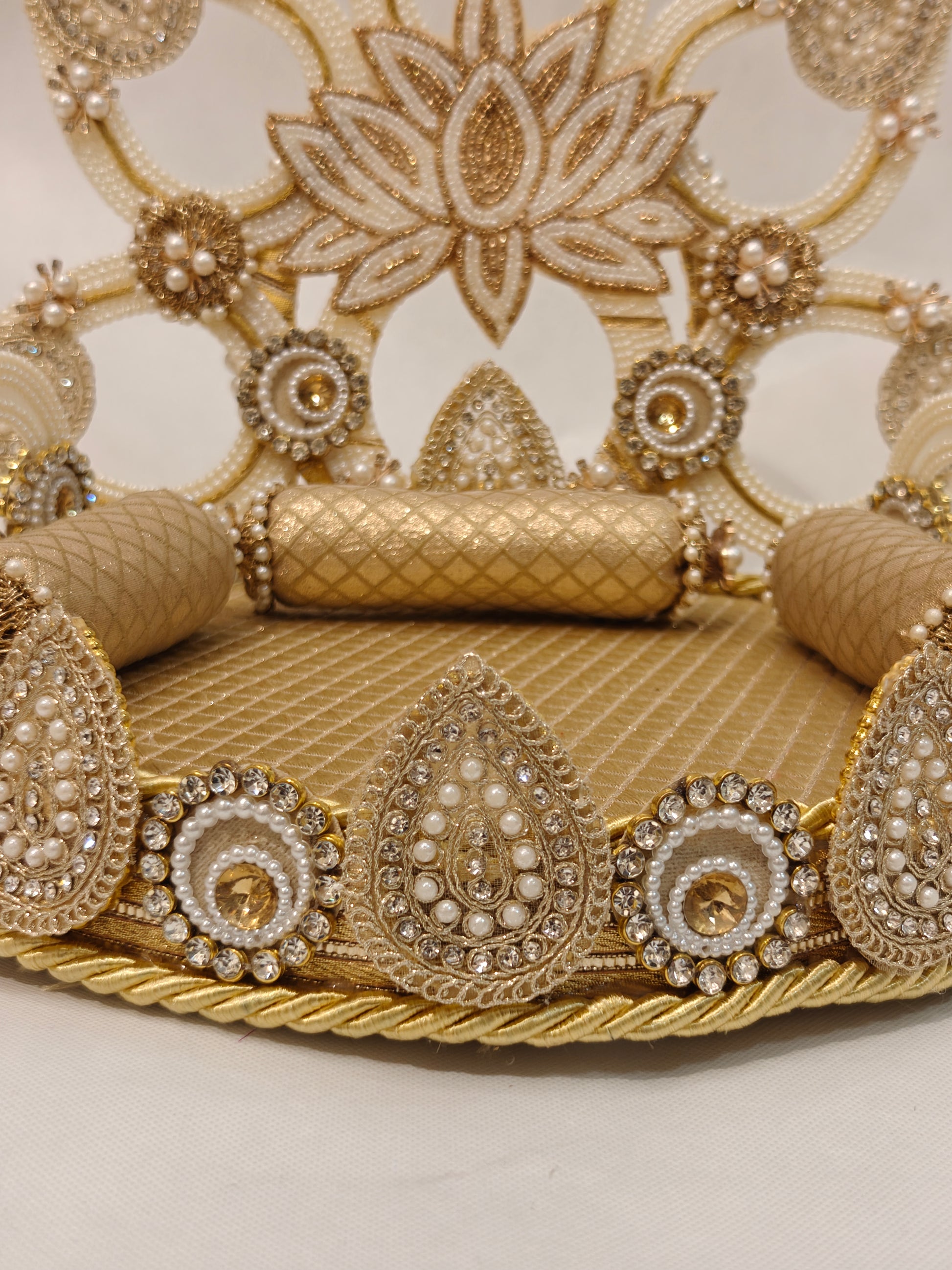 Detail view of gold lotus Singhaasan base border — teardrop and circle motifs with seed pearls, champagne rhinestones, gold rope trim and quilted fabric seating by The Wedding Station
