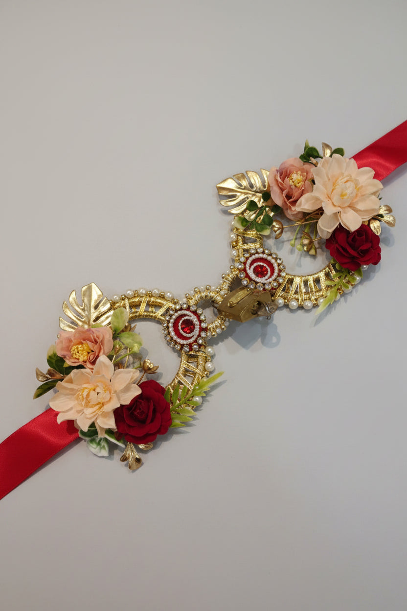 Close-up of gold and red gemstone floral lock with pearl and rhinestone embellishment on Welcome Bahurani ribbon