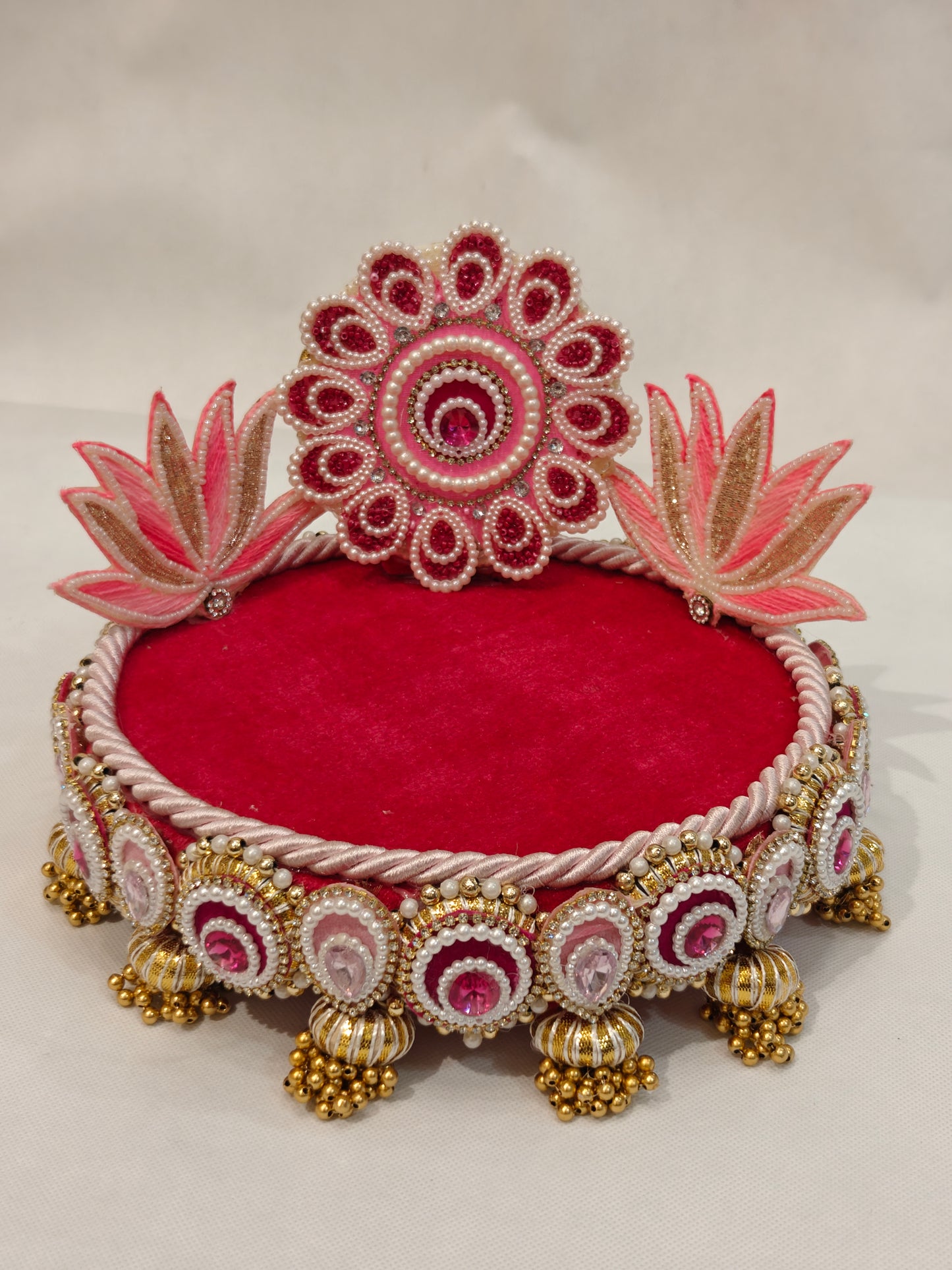 Handcrafted pink lotus Singhaasan for Ladoo Gopal — 8 inch compact MDF deity throne with beaded floral medallion crown, twin lotus blooms, crimson velvet seating, pearl gem border and gold ghungroo tassel drops by The Wedding Station