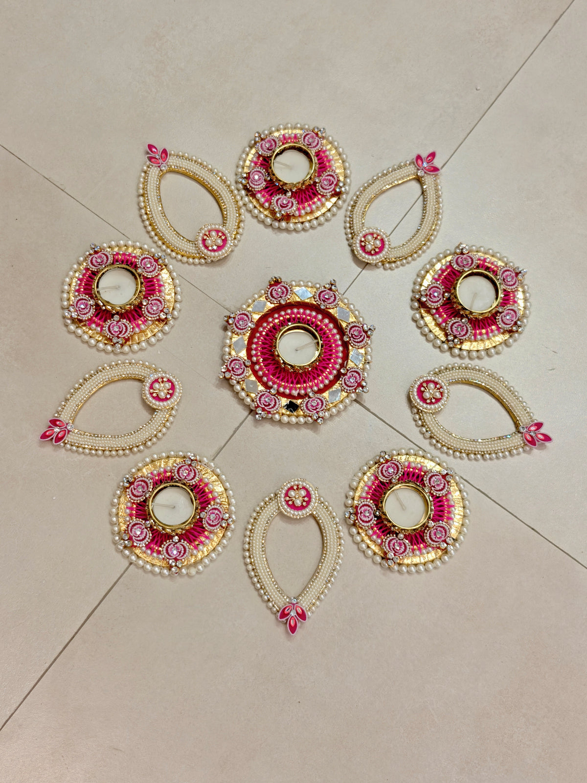 Ivory and magenta pearl rangoli set with teardrop-shaped tealight holders