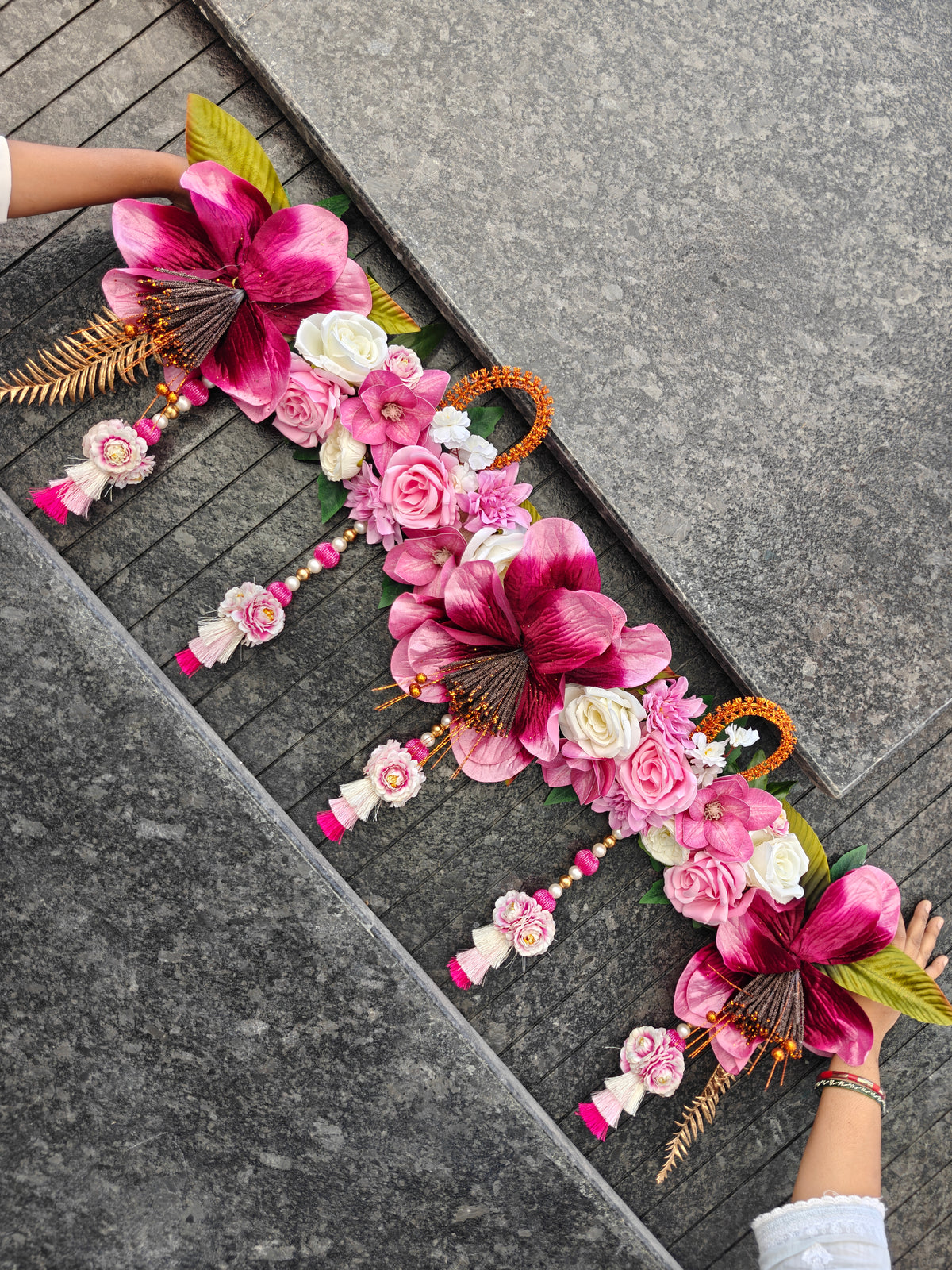 Magenta pink floral toran with large lily blooms, pink and white roses, golden fern and pearl tassel latkans