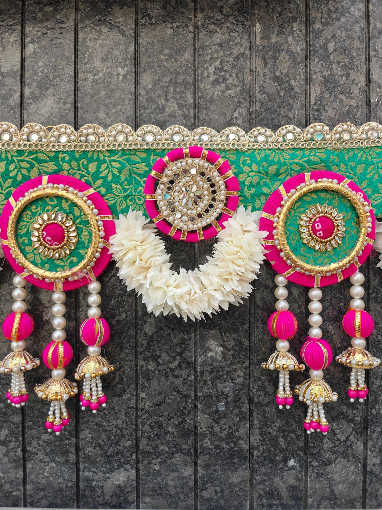 Close-up of mirror work medallion on green brocade fabric