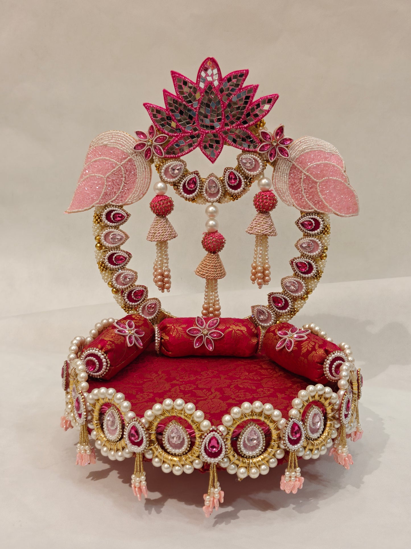 Detail view of lotus Singhaasan base and arch — gold pearl medallion border, pink tassel jhoomars, magenta brocade seating and kundan gem teardrops by The Wedding Station