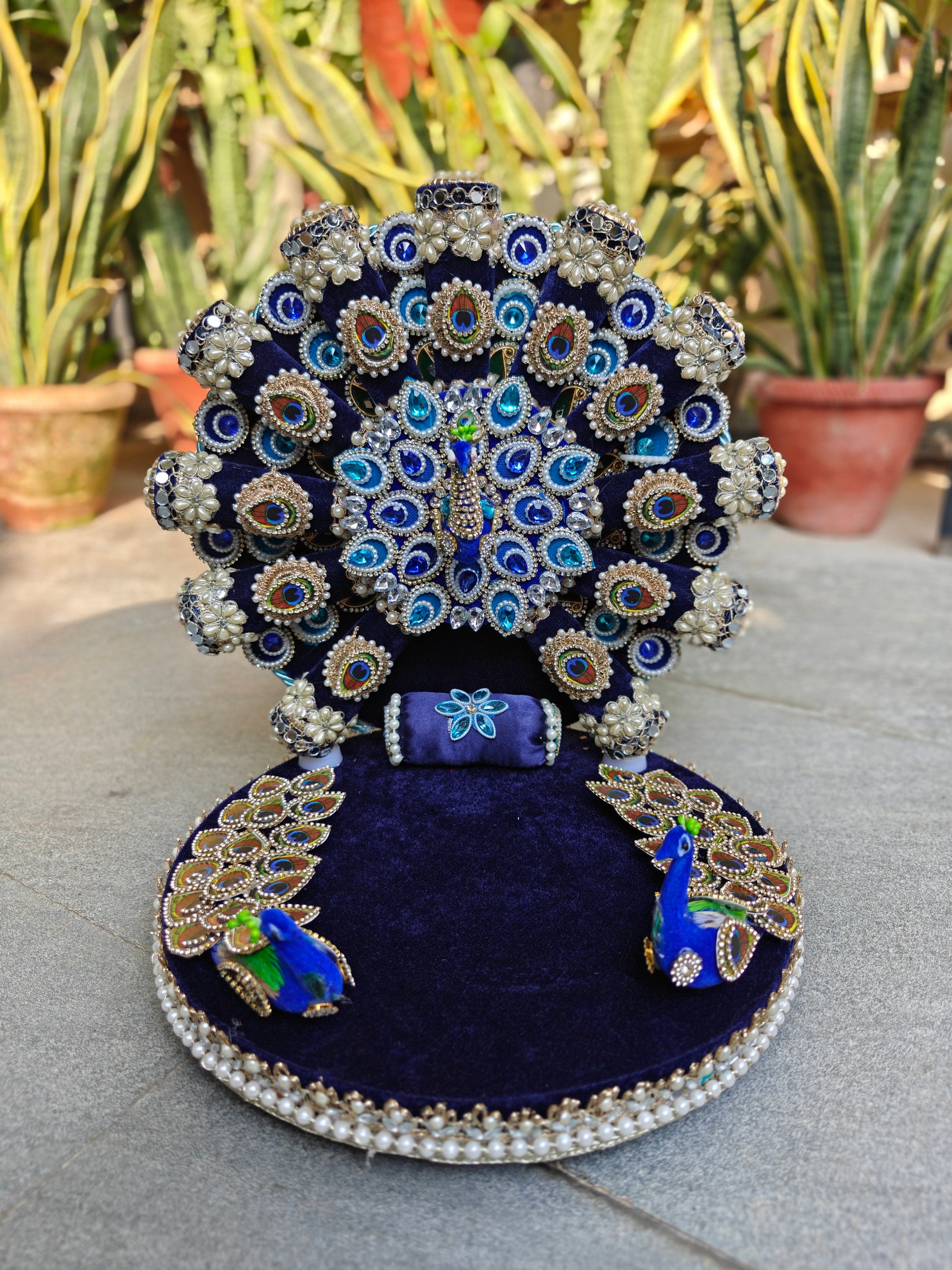 Peacock singhasan for Ladoo Gopal – front view showing royal blue velvet aasan, pearl border base, 3D peacock figurines and embellished fan backrest
