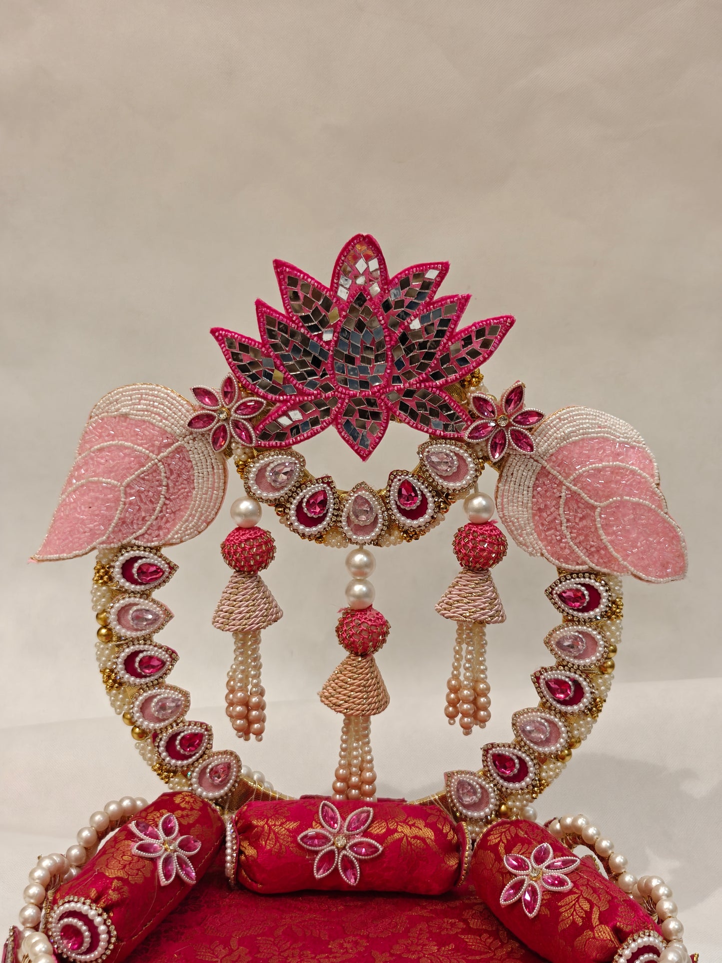 Close-up of lotus Singhaasan backdrop for Ladoo Gopal — mirror mosaic lotus crown, pink beaded elephant arch, pearl jhoomar tassels and fuchsia gem work by The Wedding Station