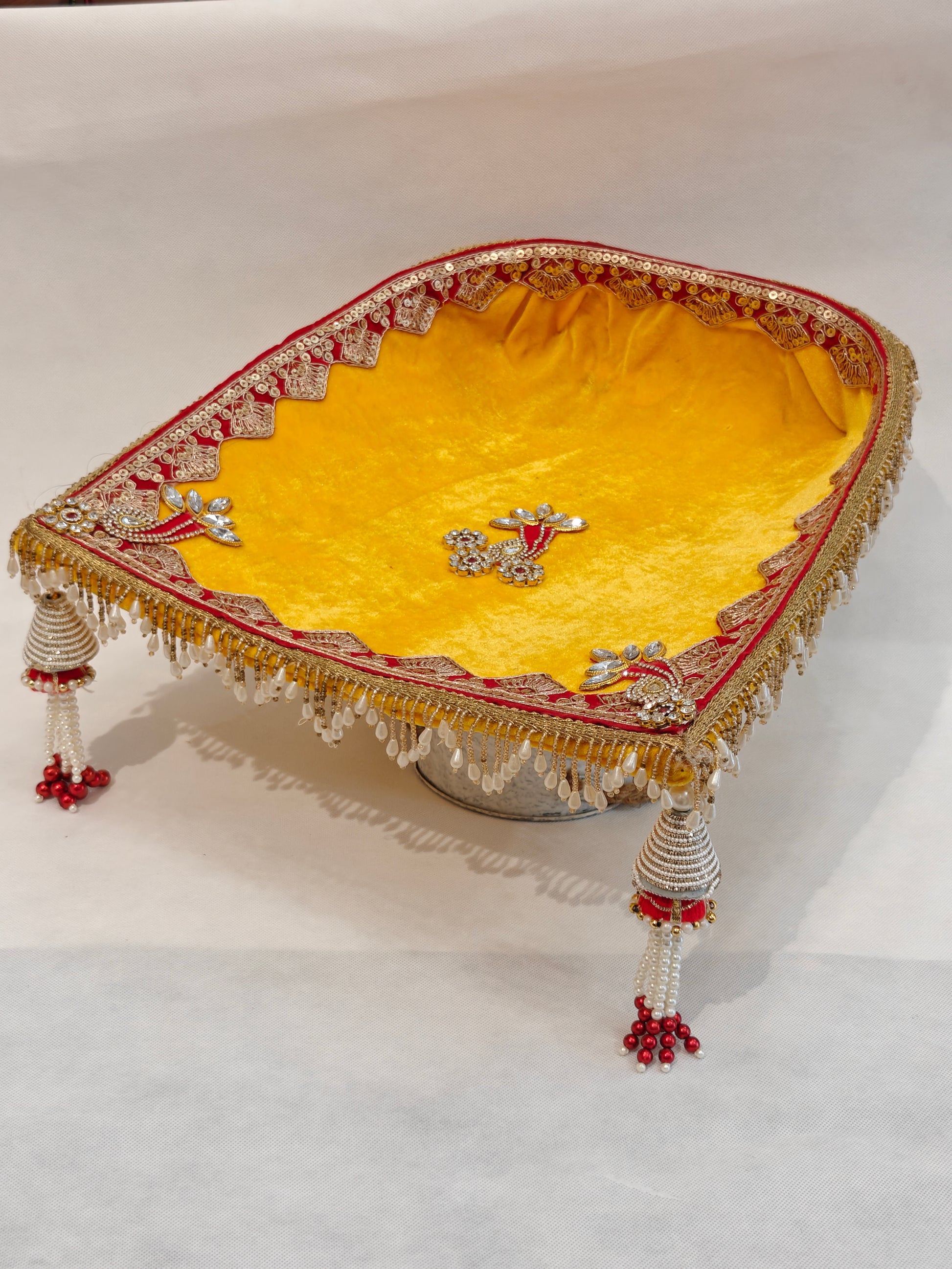 Large yellow velvet soupda 12x13 inch with red zari border, crystal peacock appliqué and white bead tassel drops — handcrafted Indian wedding ceremony tray by The Wedding Station