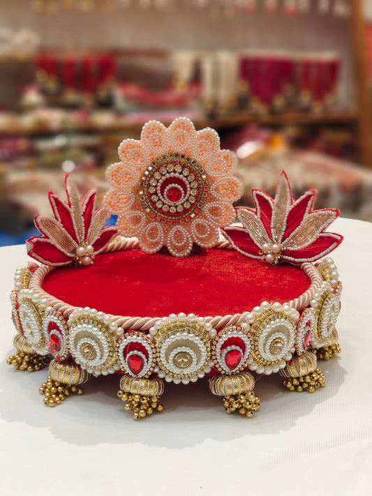 Handcrafted peach and red lotus Singhaasan for Ladoo Gopal — 8 inch compact MDF deity throne with peach pearl floral medallion crown, twin red gold lotus blooms, deep red velvet seating, pearl circle teardrop border and gold ghungroo tassel drops by The Wedding Station